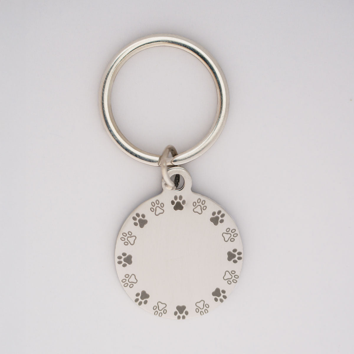 personalisierte hundemarke aus edelstahl in silber mit einem pfoten-ring