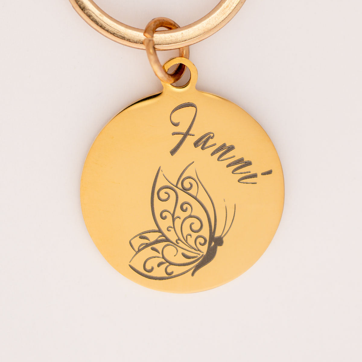 personalisierte goldenen Edelstahl Hundemarke mit einem stilisierten Schmetterling und dem Namen Fanni