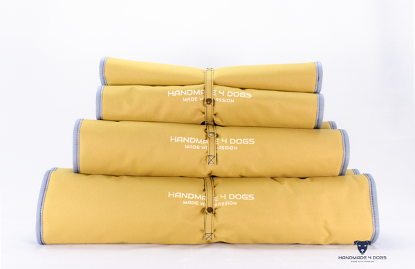 aufgerolltes-handgefertigtes-Hunde-Reisebett-von-handmade-4-dogs-in-der-Farbe-Senf-mit-wedgwood-farbiger-Einfassung-und-einer-Liegefläche-aus-dunklem-Denim