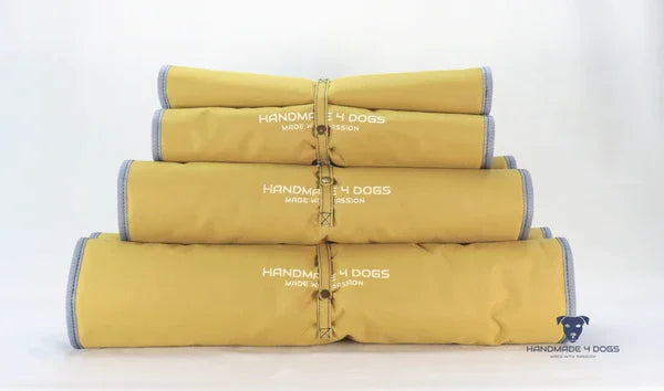 aufgerolltes-handgefertigtes-Hunde-Reisebett-von-handmade-4-dogs-in-der-Farbe-Senf-mit-wedgwood-farbiger-Einfassung-und-einer-Liegefläche-aus-dunklem-Denim