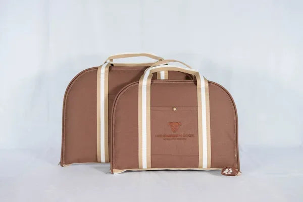 Hunde Reisebett in haselnussbraun mit gestreiften Riemen in beige und weiß, die liegefläche dieses handgefertigten Hunde Reisebettes ist eine Rosenholzfarbene kuscheldecke