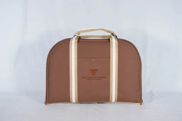 Hunde Reisebett in haselnussbraun mit gestreiften Riemen in beige und weiß, die liegefläche dieses handgefertigten Hunde Reisebettes ist eine Rosenholzfarbene kuscheldecke