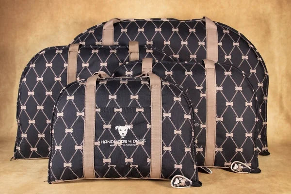 handgefertigtes-Hunde-Reisebett-grundfarbe-ist-schwarz-darüber-Rhomben-in-gold-derren-schnittpunkte-knochen-sind-die-Taschengurte-sind-in-rosenholz-farben-die Kuscheldecke-die-als-liegefläche-dient-ist-ebenso-aus-einem-rosenholzfarbenen-kuschelstoff