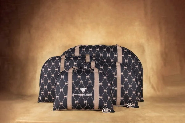 handgefertigtes-Hunde-Reisebett-grundfarbe-ist-schwarz-darüber-Rhomben-in-gold-derren-schnittpunkte-knochen-sind-die-Taschengurte-sind-in-rosenholz-farben-die Kuscheldecke-die-als-liegefläche-dient-ist-ebenso-aus-einem-rosenholzfarbenen-kuschelstoff