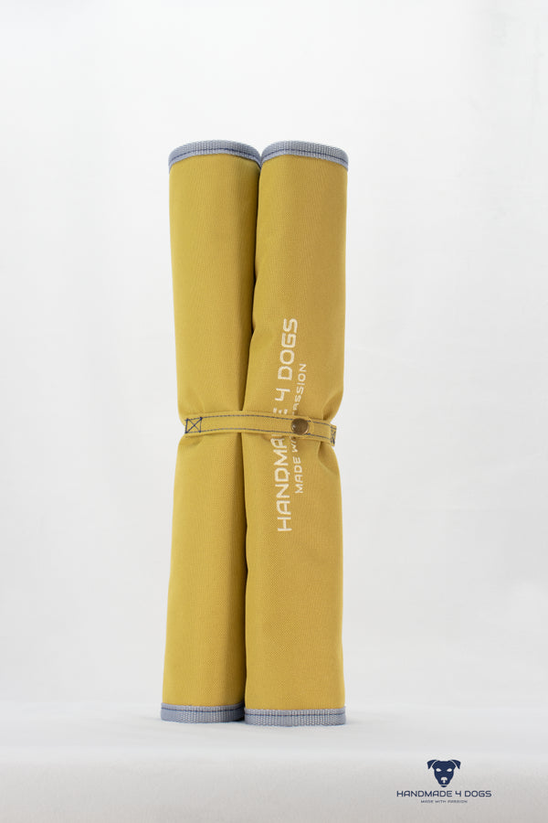 aufgerolltes-handgefertigtes-Hunde-Reisebett-von-handmade-4-dogs-in-der-Farbe-Senf-mit-wedgwood-farbiger-Einfassung-und-einer-Liegefläche-aus-dunklem-Denim