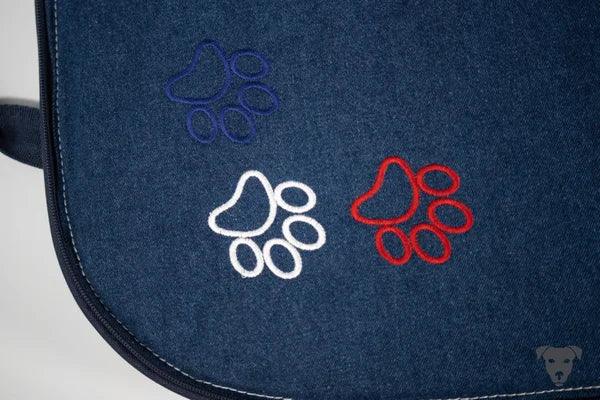 Hunde-Reisebett-handgefertigt-von-handmade-4-dogs-in-Taschenform-im-Design-der-französischen-Nationalfarben-blau-weiß-rot-die-Taschengurte-sind-in-dunkelblau-die-liegefläche-ist-aus-einem-schwerem-Jeansstoff-welcher-mit-3-Pfoten-bestickt-ist-ebenso-in-den-Farben-der-Tricolore