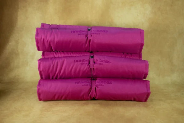 gerolltes-hunde-reisebett-handgefertigt-von-handmade-4-dogs-in-pinkem-wasserdichten-aussenmaterial-und-innen-mit-einem-hellen-jeansstoff-mit-sternen-dekor