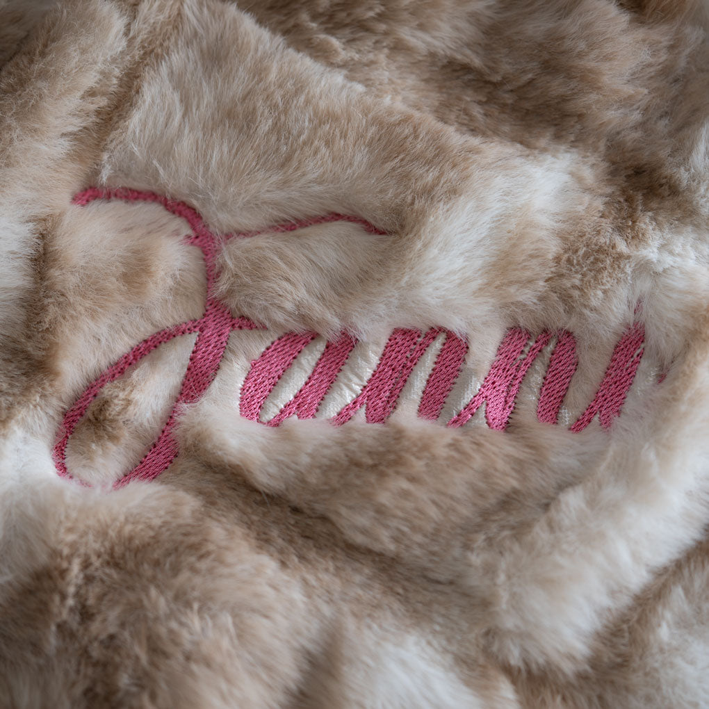 Detailansicht des gestickten Namens "Fanni" im Webpelz