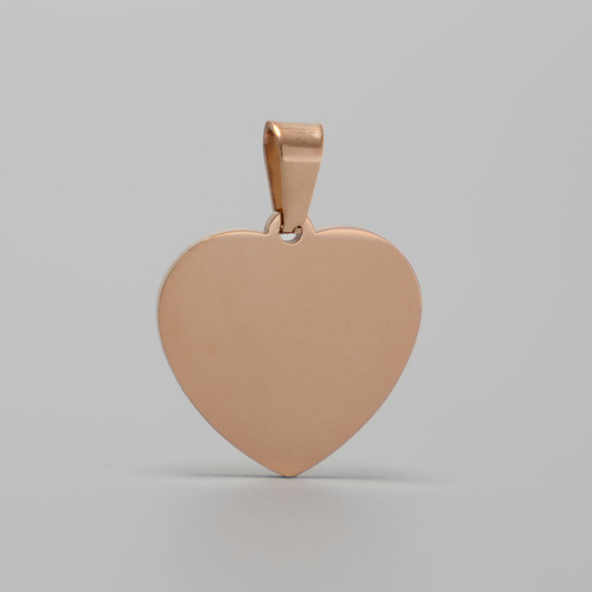 Roségoldfarbener Edelstahl-Herzanhänger, 21 × 21 mm, ohne Gravur in der Vorderansicht auf grauem Hintergrund.