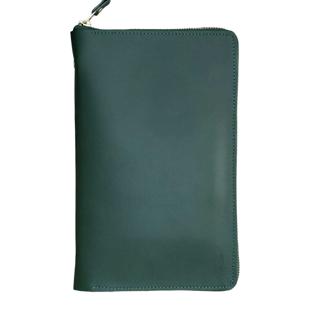 Freigestellter Travel Organizer aus grünem Leder. Das geschlossene Etui besticht durch ein minimalistisches Design, das durch den umlaufenden goldenen Messing-Reißverschluss elegant abgerundet wird.