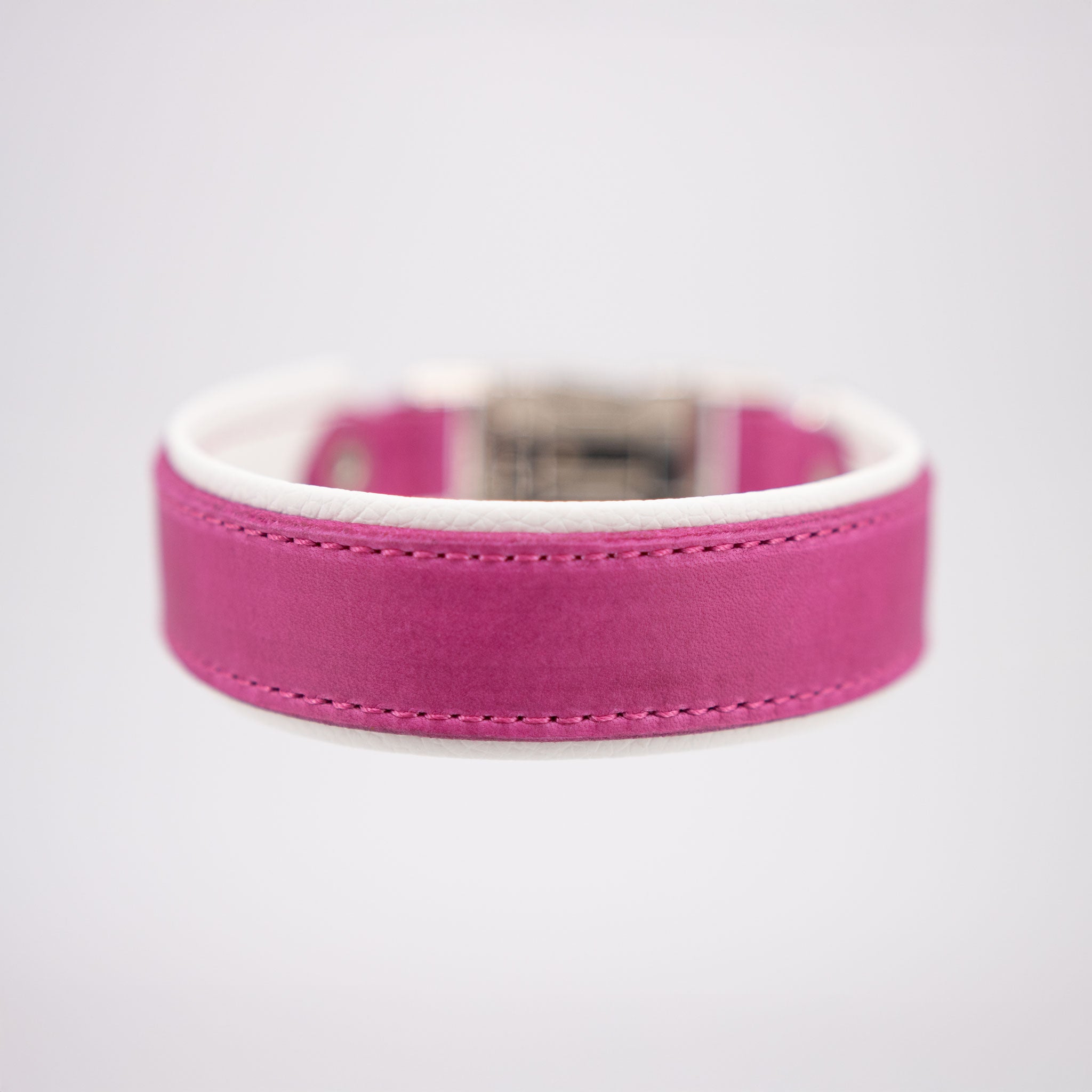 Frontansicht eines handgefertigten Hundehalsbands aus pinkem Fettleder mit weißer Polsterung.