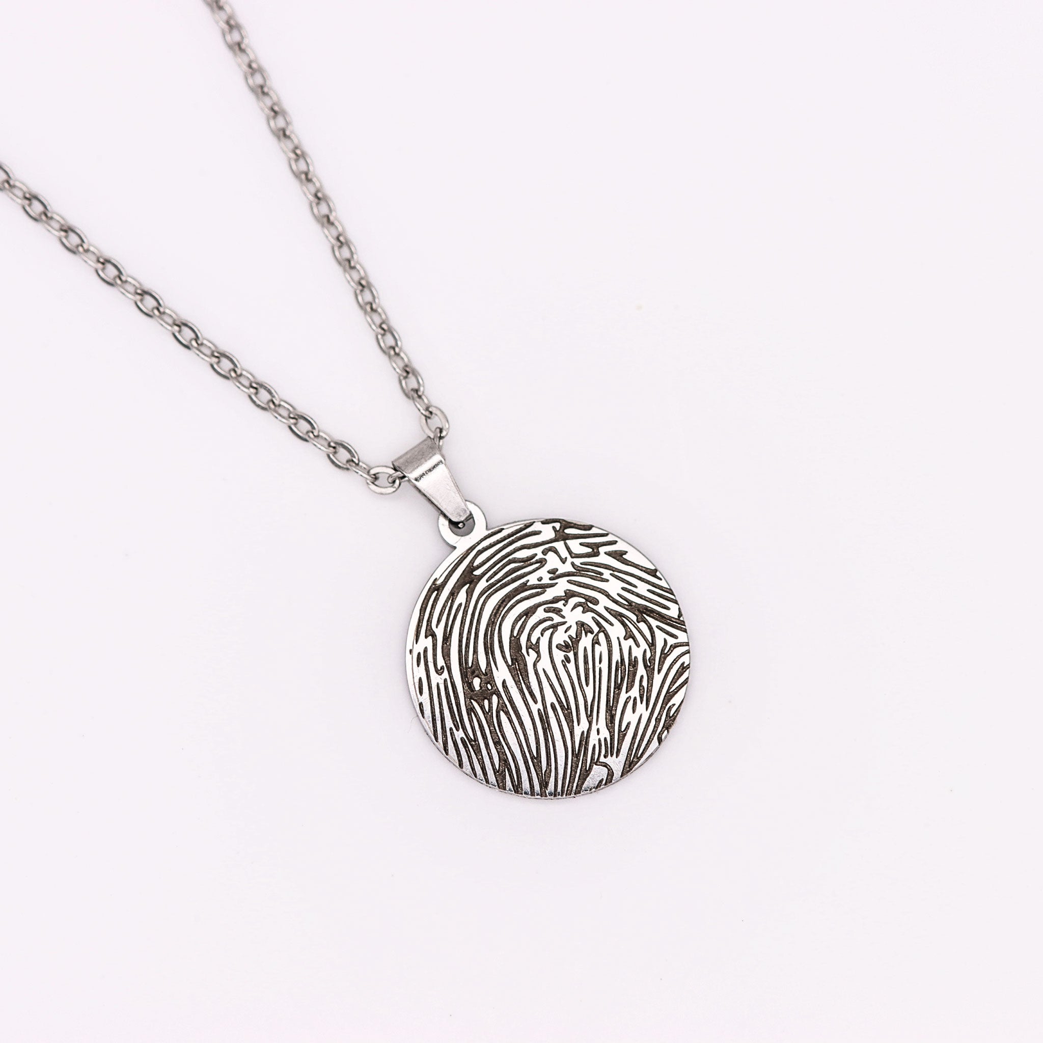 Detailansicht einer Halskette mit graviertem Fingerabdruck in Silbe