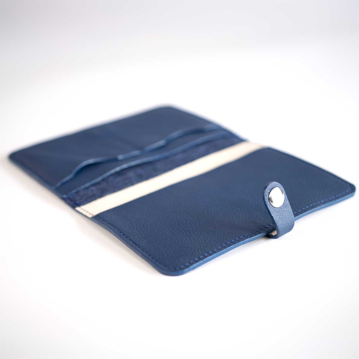 Innenansicht der leeren Leder-Filz-Impfpasshülle mit edlem Off-White Kalbslederfutter und marineblauen Lederfächern.