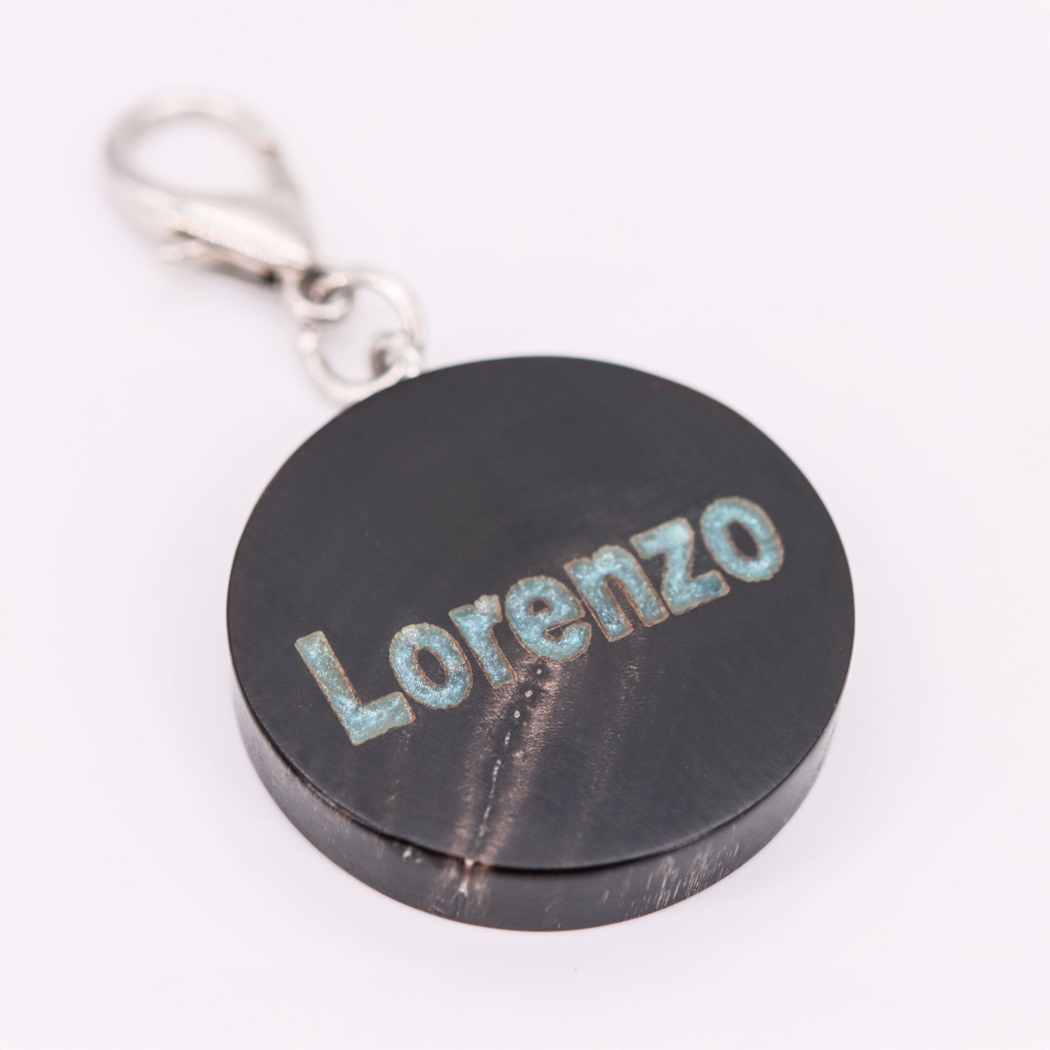 Personalisierte Hundemarke aus schwarzem Büffelhorn mit blauer Namensgravur und silbernem Karabiner