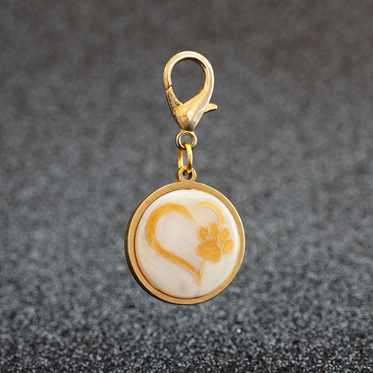 Personalisierte goldene Hundemarke mit Herz-Pfote-Motiv auf einer echten weißen Muschelplatte