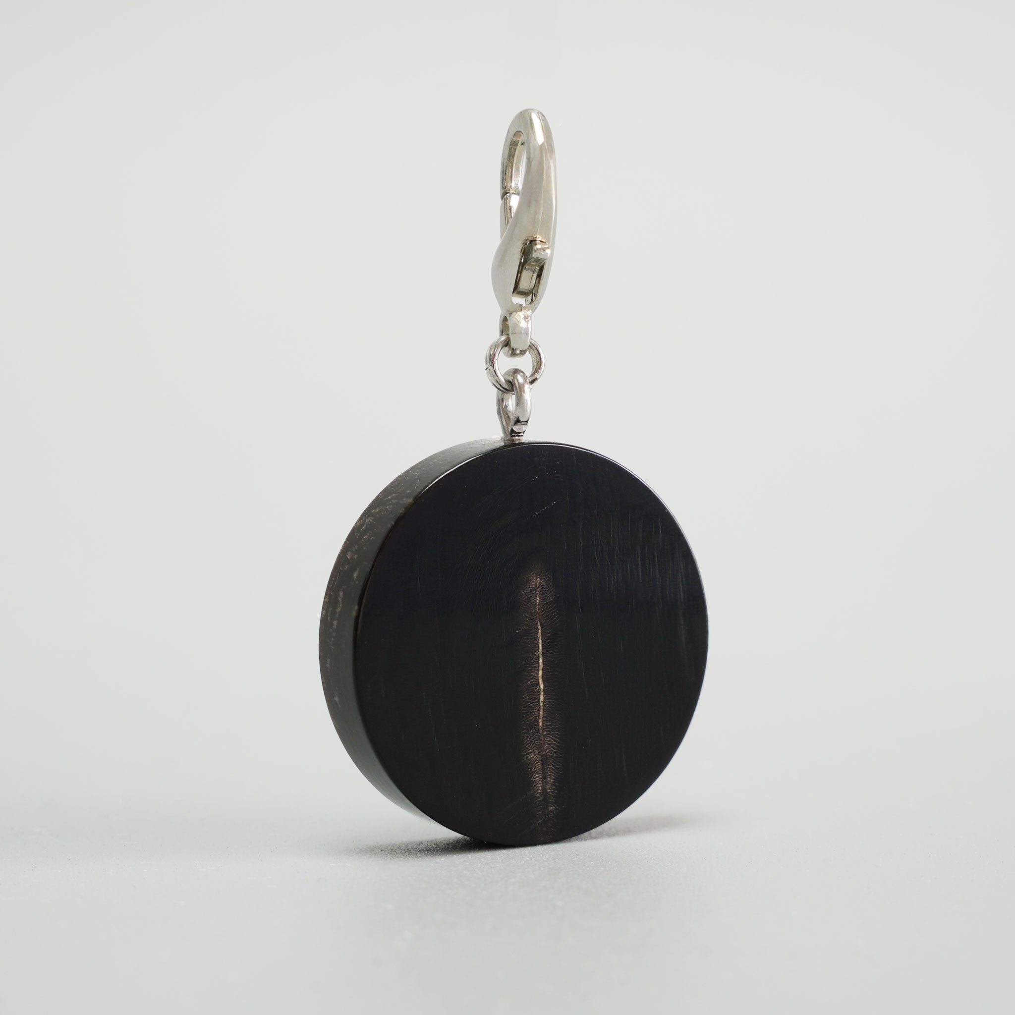 Detailansicht einer handgefertigten Hundemarke aus echtem schwarzem Büffelhorn mit Fokus auf Materialstruktur