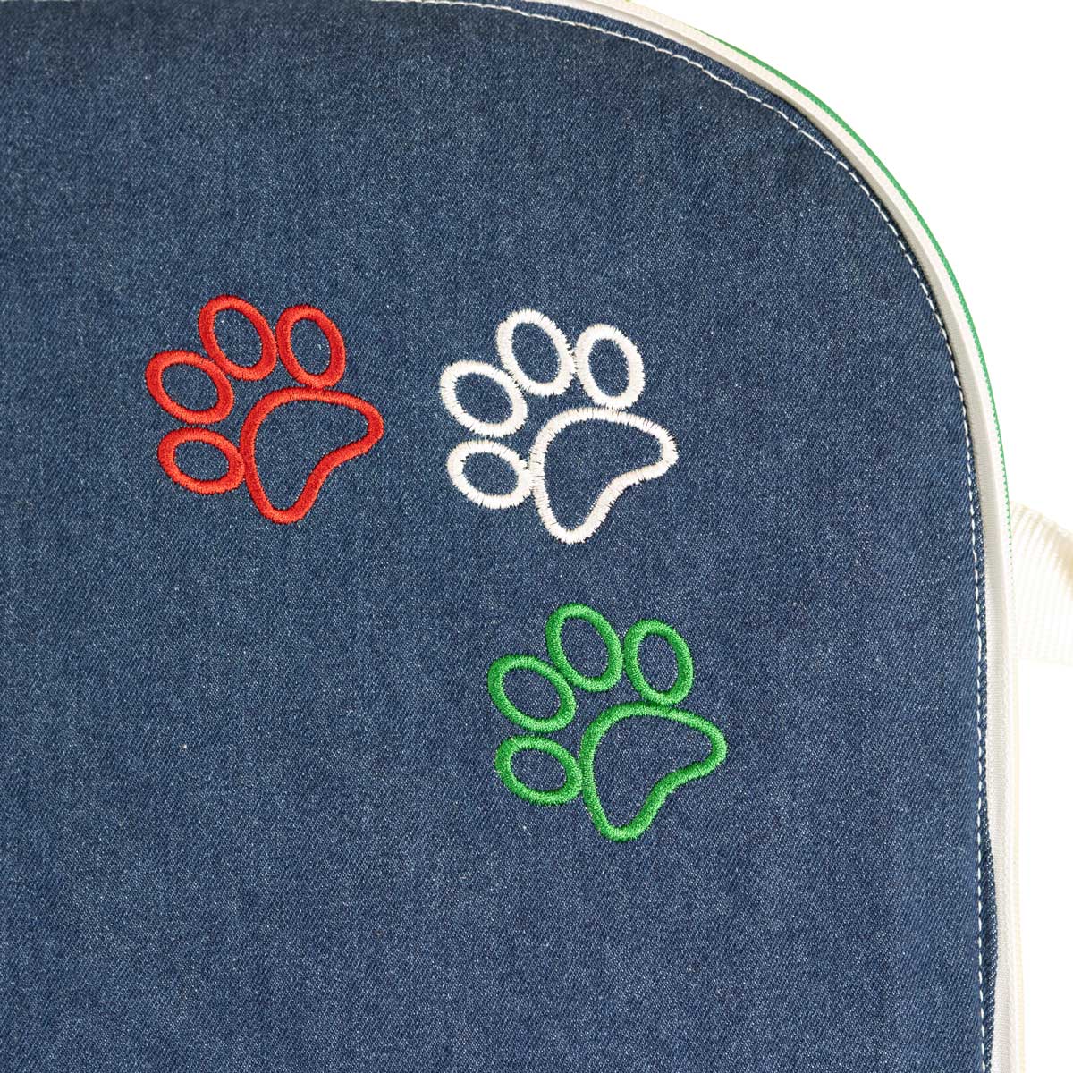 Detail der gestickten Pfoten in Grün, Weiß und Rot auf der Denim-Liegefläche des Hundereisebetts Bella Italia