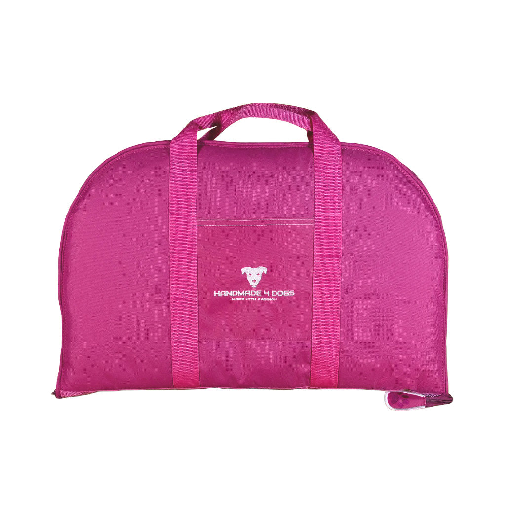 Handgefertigtes Hundereisebett Dog Bed To Go in Pink, geschlossen als Tragetasche mit pinken Tragegurten und Fronttasche.