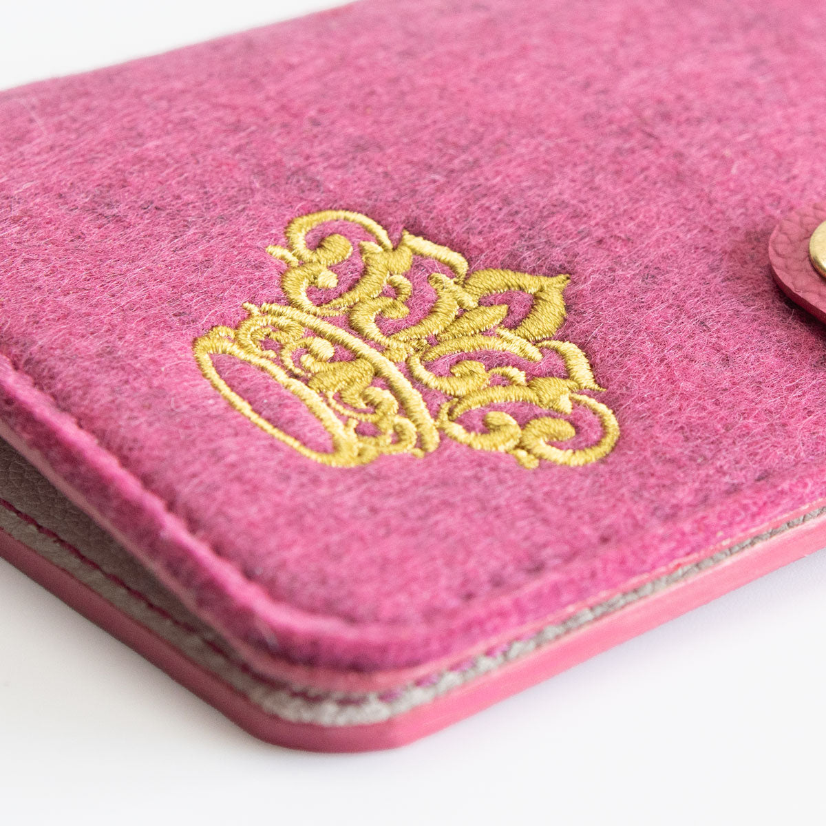 Detailaufnahme des präzisen Kronen-Sticks auf der Vorderseite der pinken Heimtierausweishülle.