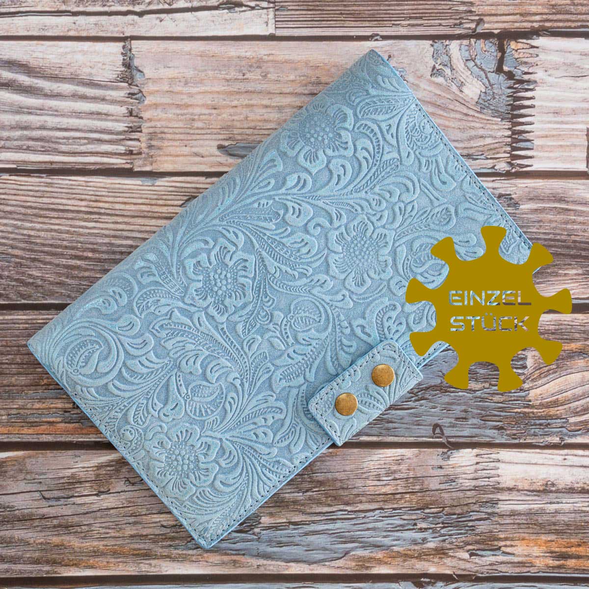 Handgefertigtes Travel Wallet für zwei Pässe Einzelstück. Das hellblaue, italienische Taschenleder besticht durch eine filigrane florale Prägung und zwei altmessingfarbene Druckknöpfe