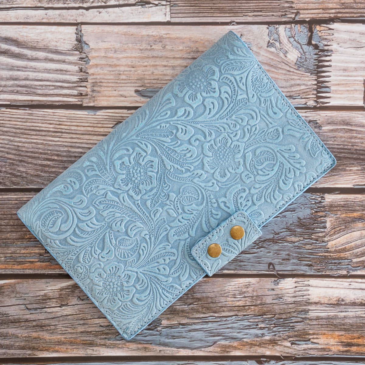 Handgefertigtes Travel Wallet für zwei Pässe. Das hellblaue, italienische Taschenleder besticht durch eine filigrane florale Prägung und zwei altmessingfarbene Druckknöpfe