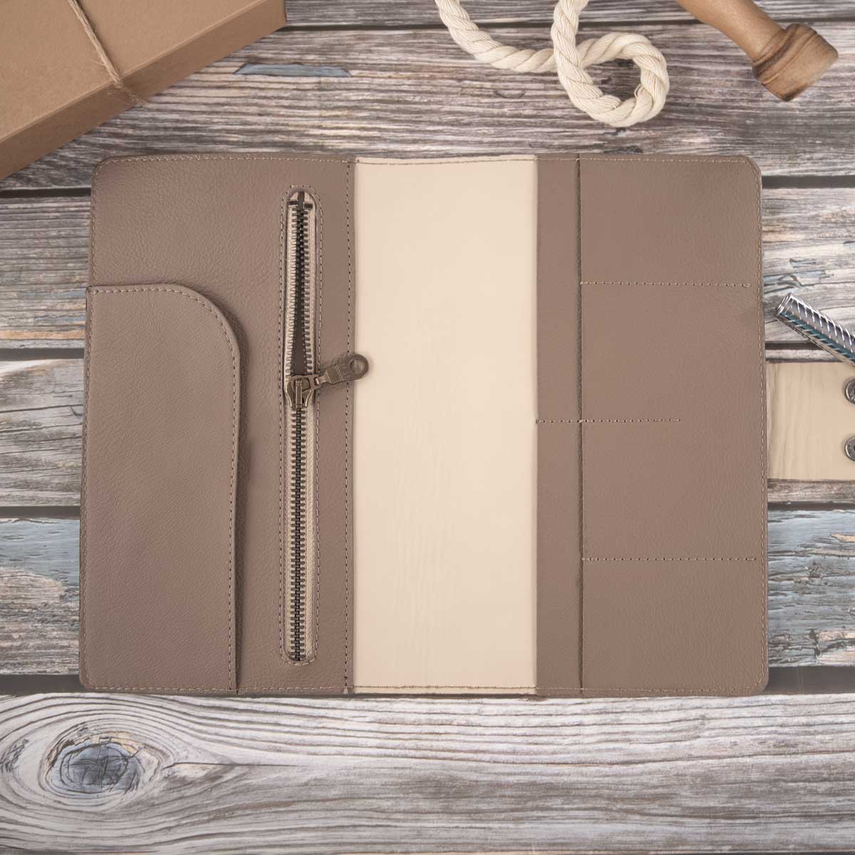 Innenansicht der taupefarbenen Reisepasshülle aus Leder, zeigend das beige Kalbsleder, vier Kartenfächer und ein großes Zippfach.