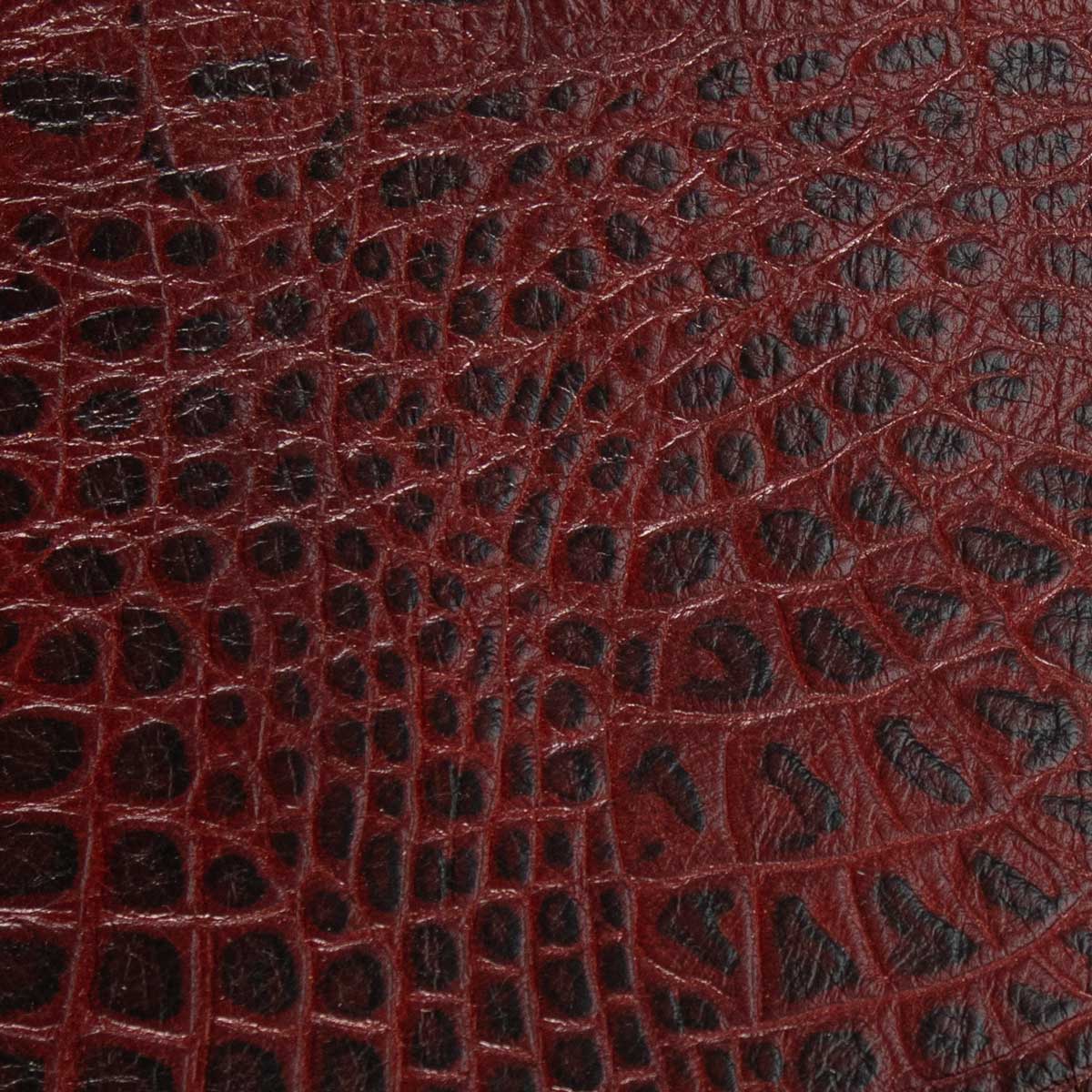 Nahaufnahme des schweren italienischen Taschenleders mit der detailreichen Kroko-Prägung in Rot und Schwarz.