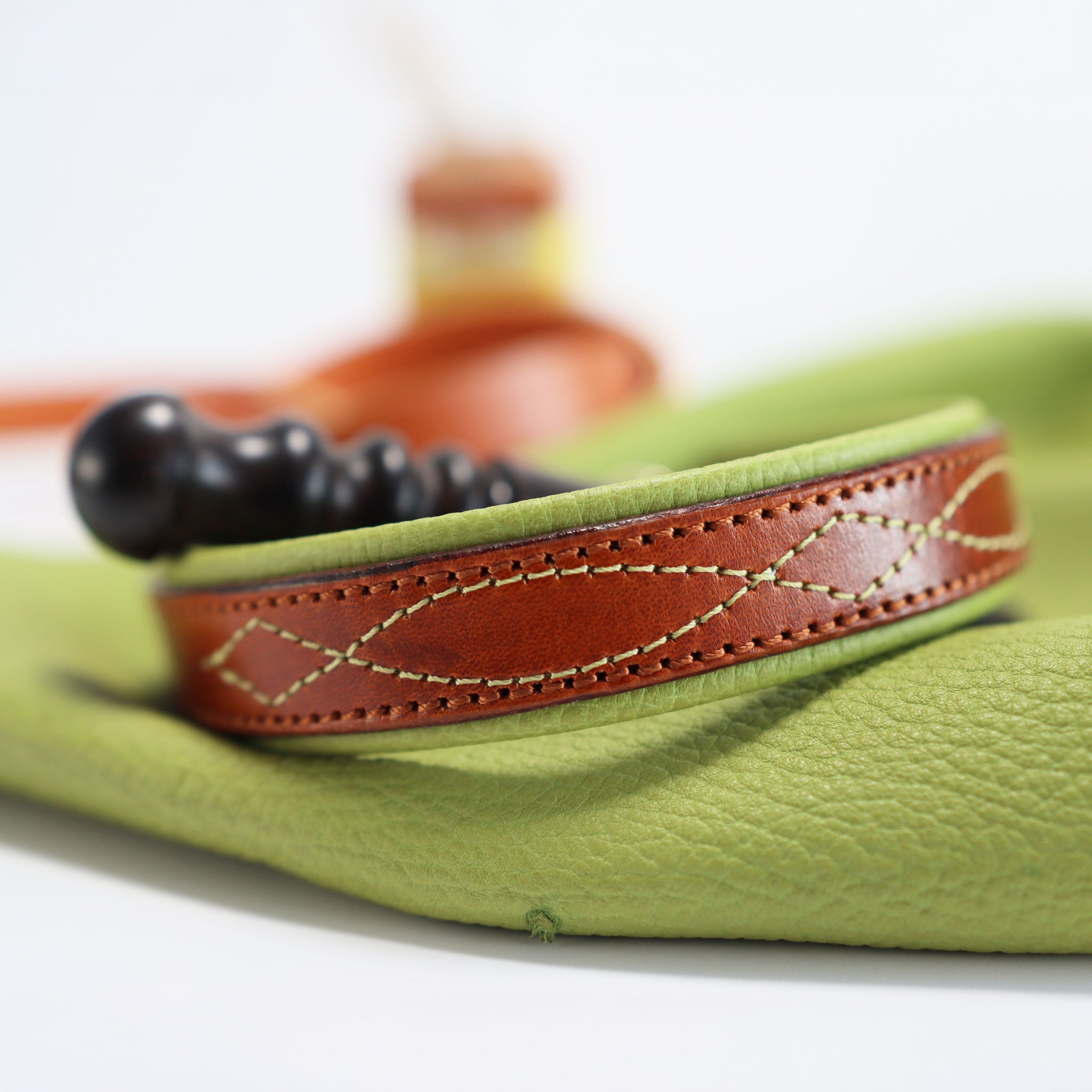 Handgefertigtes Hundehalsband präsentiert auf hochwertigem grünen Leder