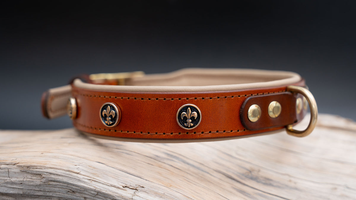 Rechte Seitenansicht des cognacfarbenen Lederhalsbands Fleur de Lys Gold mit vergoldeten Lilien und Leinenring.