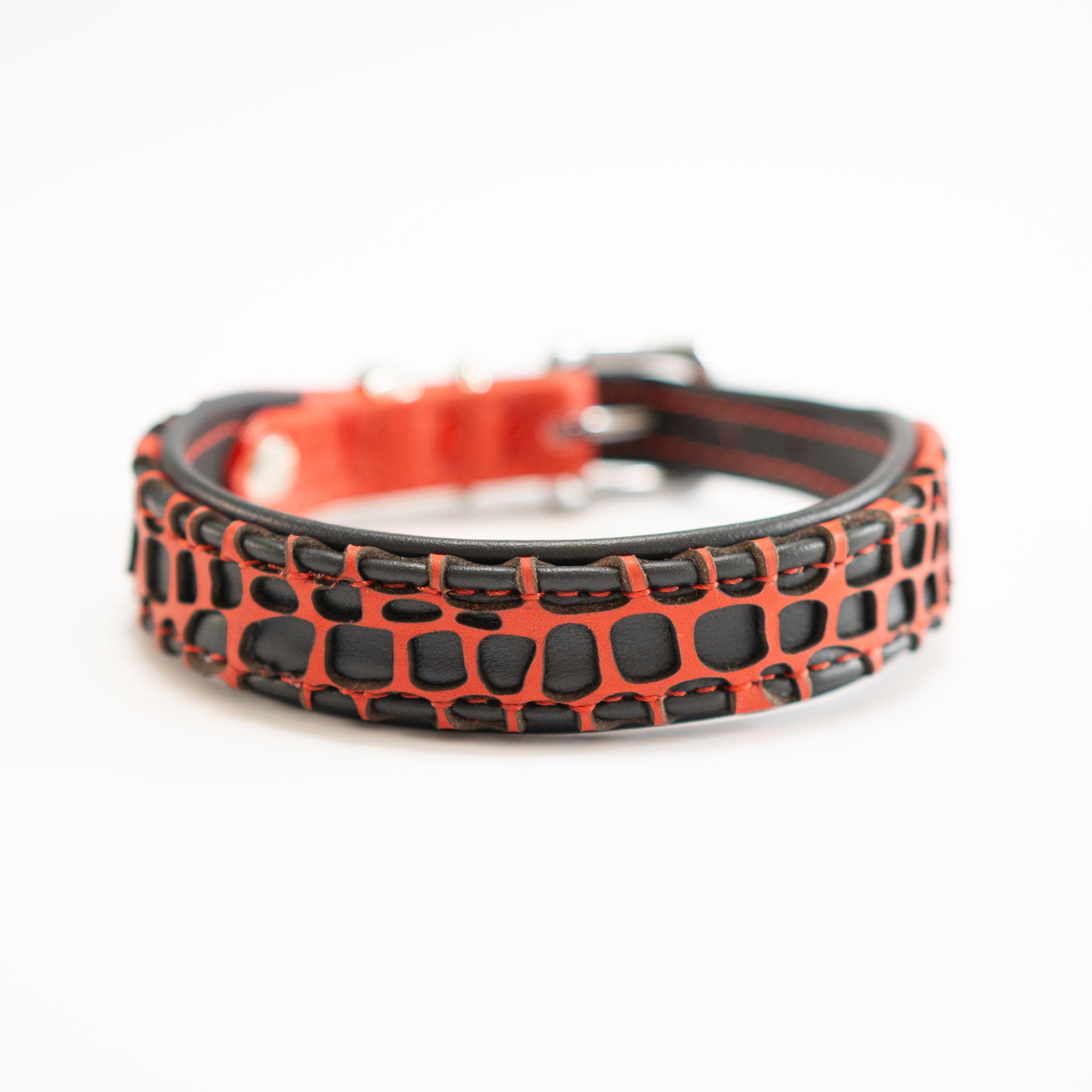 Detailansicht eines roten Hundehalsbandes aus Leder mit schwarzen laser-geschnittenen Panzerplatten