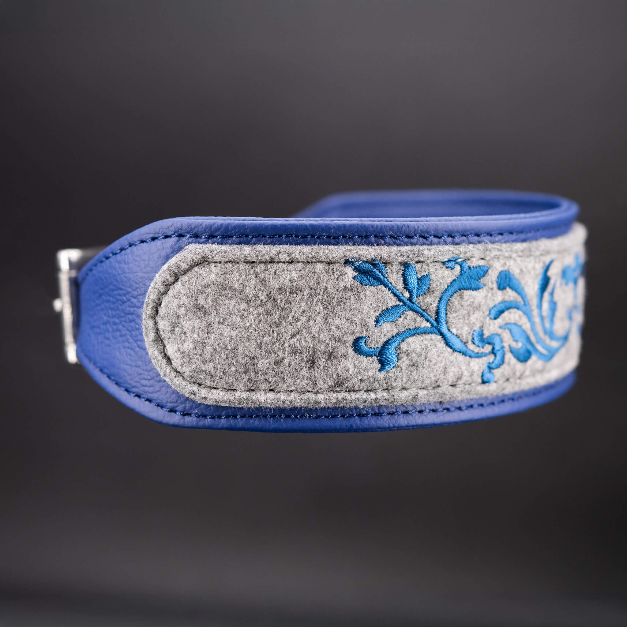 Detailansicht der Bestickung auf grauem Wollfilz und blauem Nappaleder