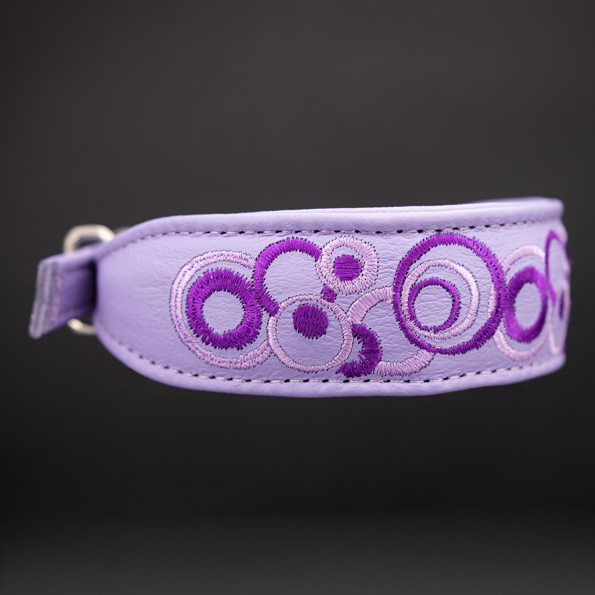 Detailaufnahme der Bi-color Stickerei und der hochwertigen Verarbeitung des fliederfarbenen Lederhalsbands