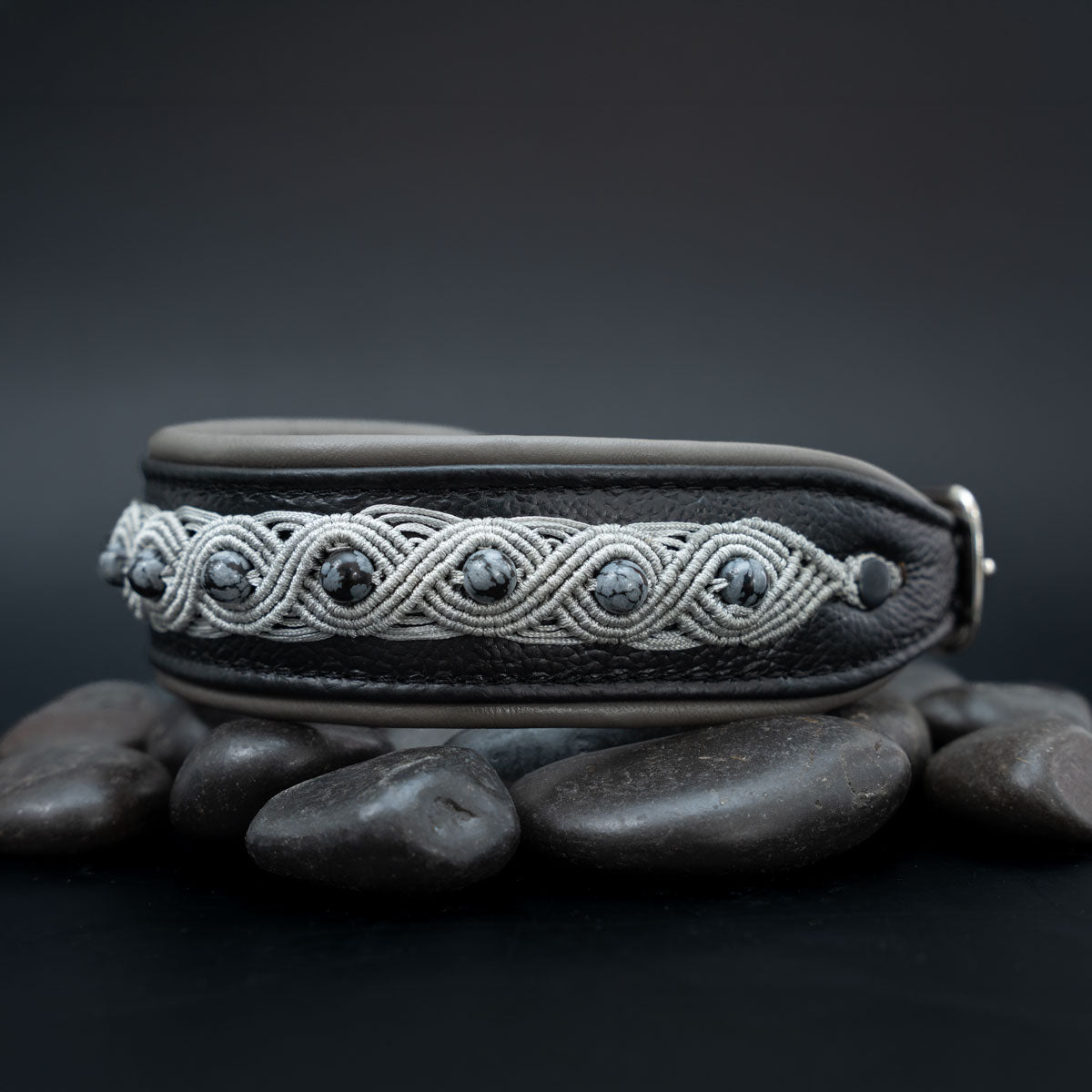 Schwarzes Halsband mit silberfarbener Knüpfborte und Schneeflockenobsidian; rechts verjüngt sich das Leder zur Schnalle.