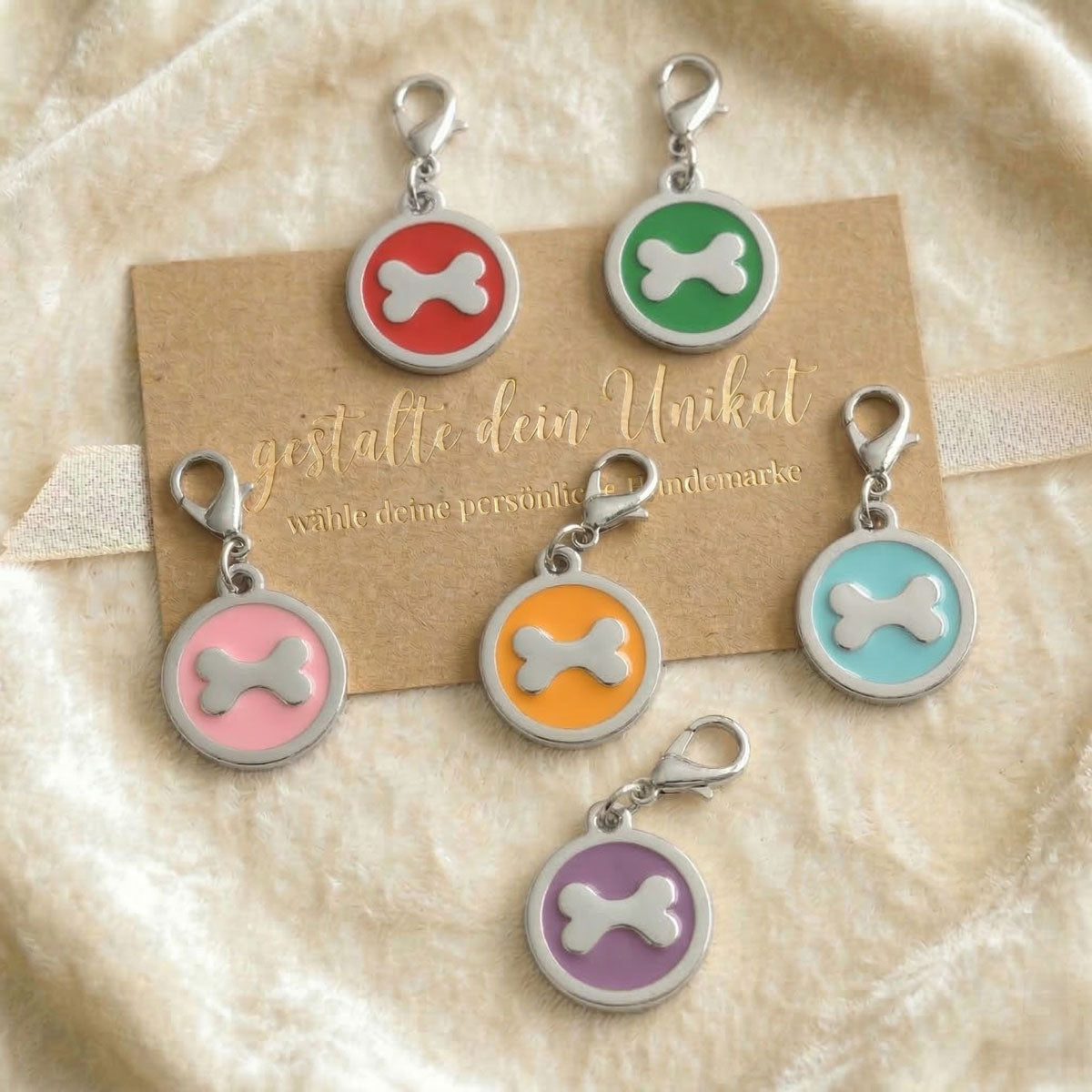 Übersicht verschiedenfarbiger Hundemarken mit Knochen-Inlay
und Gravur-Option in Rot, Rosa, Blau, Orange, Lila und Grün