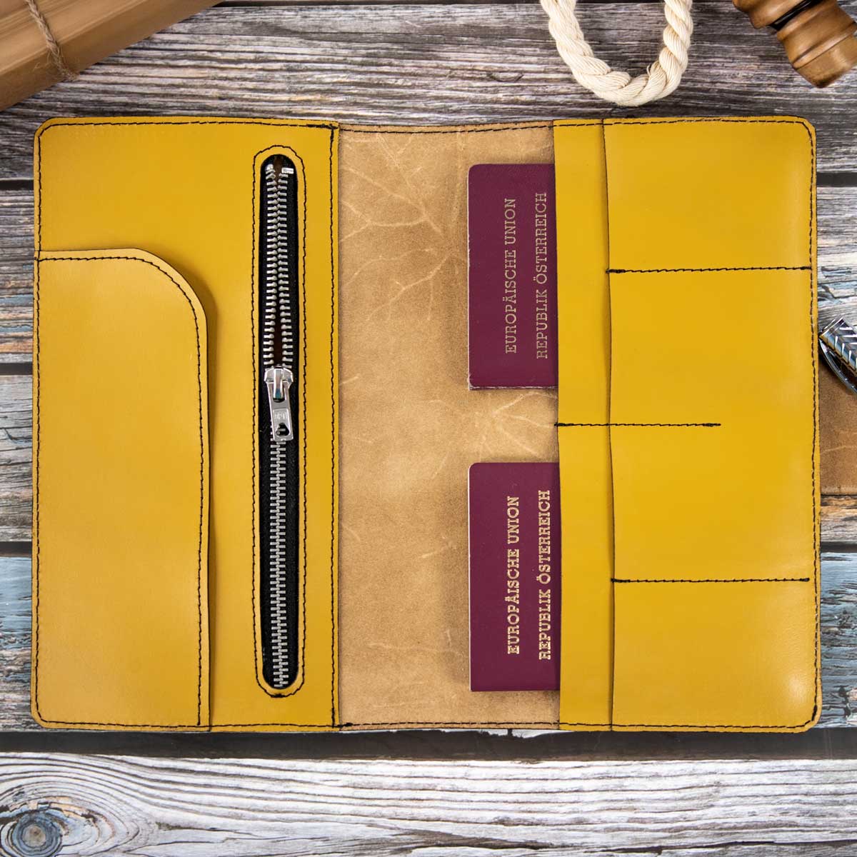Geöffnetes Leder Travel Wallet in strahlendem Maisgelb, befüllt mit zwei österreichischen Reisepässen und Reiseunterlagen