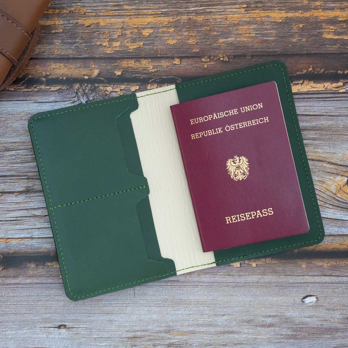 Geöffnete Premium-Reisepasshülle mit einem eingesteckten EU-Reisepass auf der rechten Seite und zwei Kreditkarten in den dafür vorgesehenen Fächern