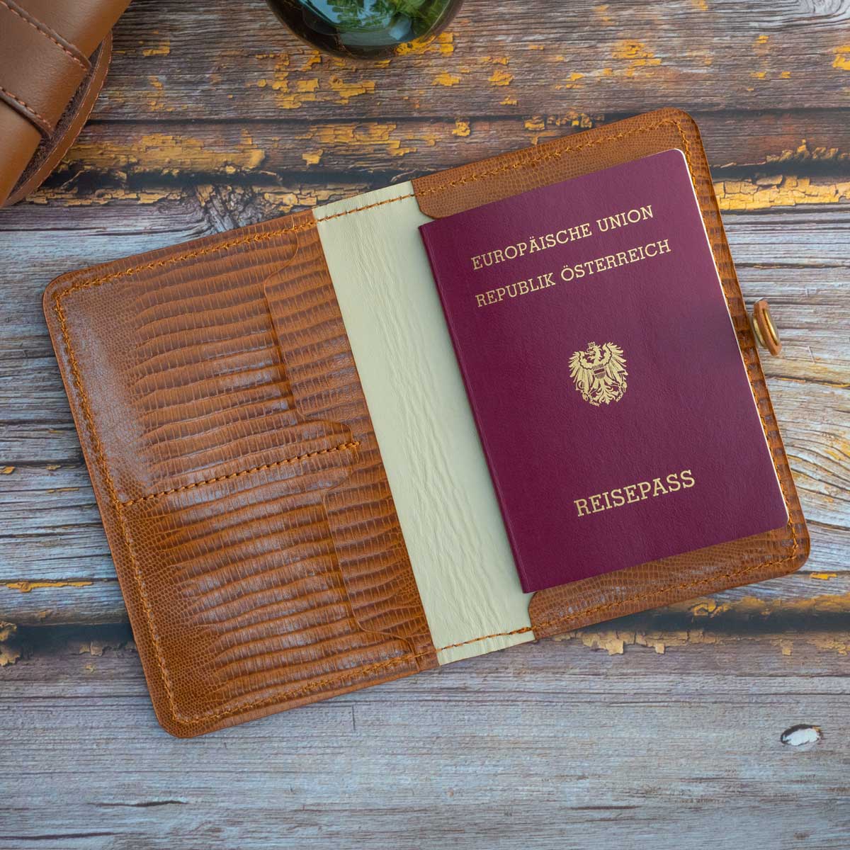Geöffnete Reisepasshülle aus Leder mit einem eingesteckten österreichischen EU-Reisepass in der rechten Innentasche.