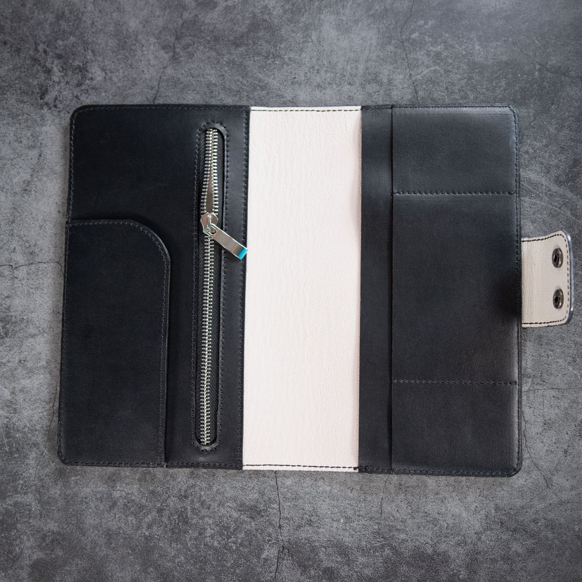 Innenansicht des Leder Travel Wallets, zeigend das helle Kalbsleder, ein Zippfach und Steckplätze für Pässe und Karten.