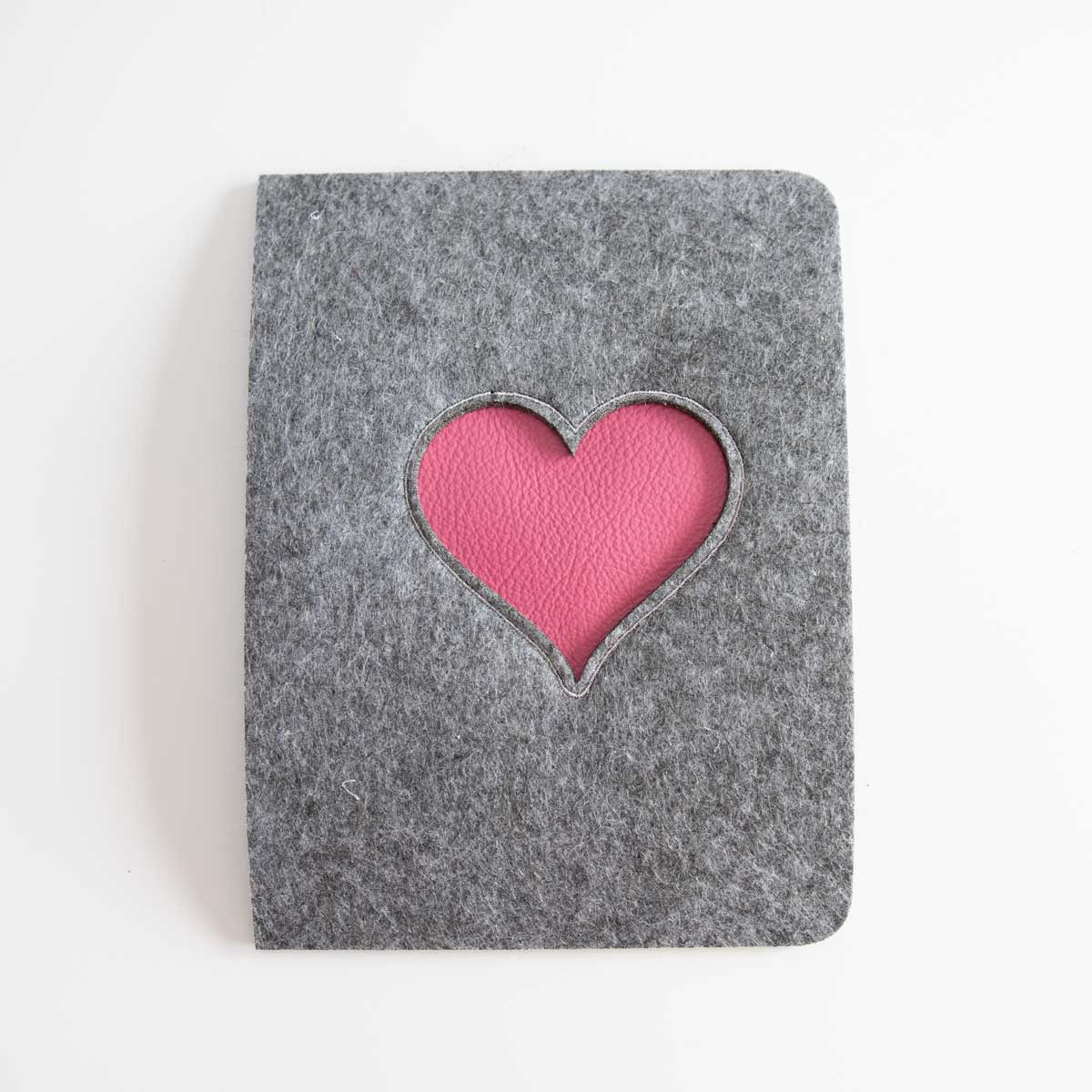Beispiel für die edle Materialunterlegung des Herz-Lasercuts mit kontrastierendem Leder, fixiert durch eine feine Stickerei.