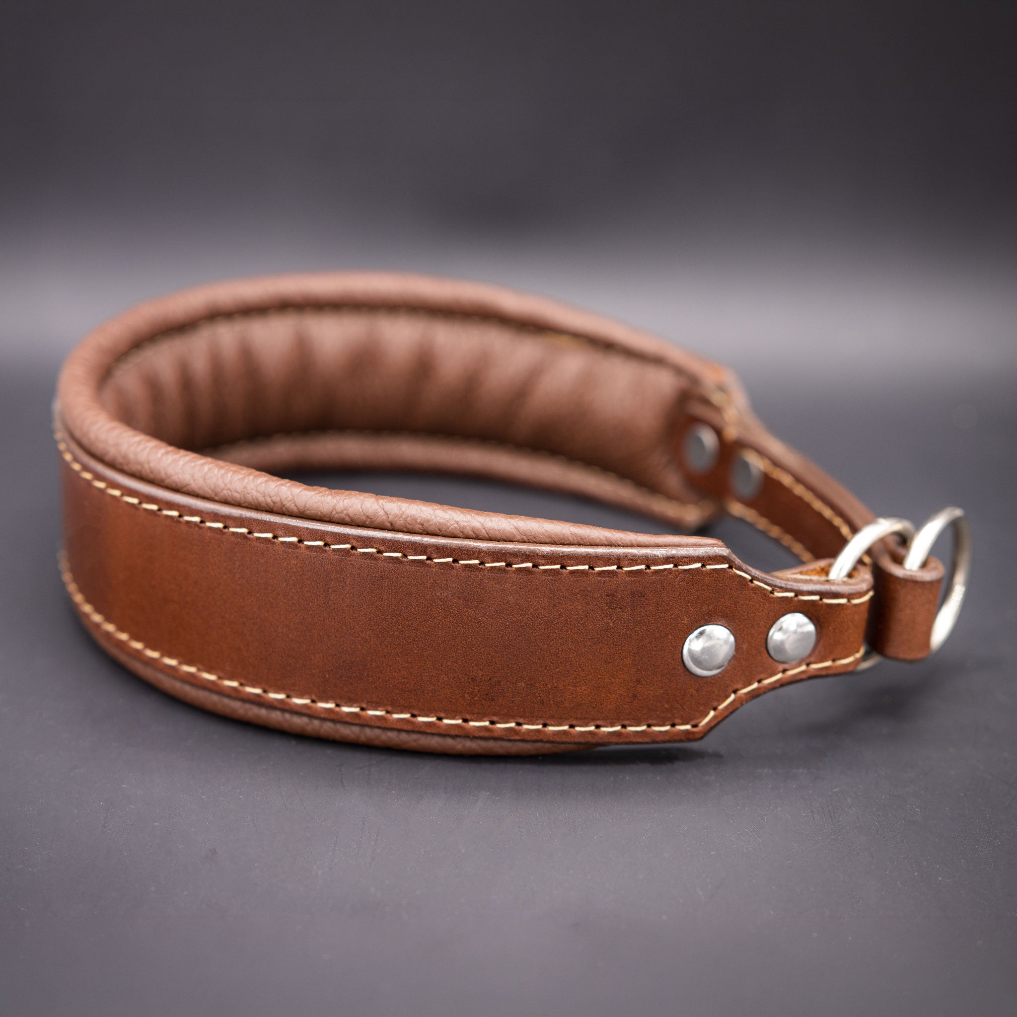 Seitenansicht des gebugten Lederhalsbands mit hochwertigen Ringen und Nappa-Unterlegung