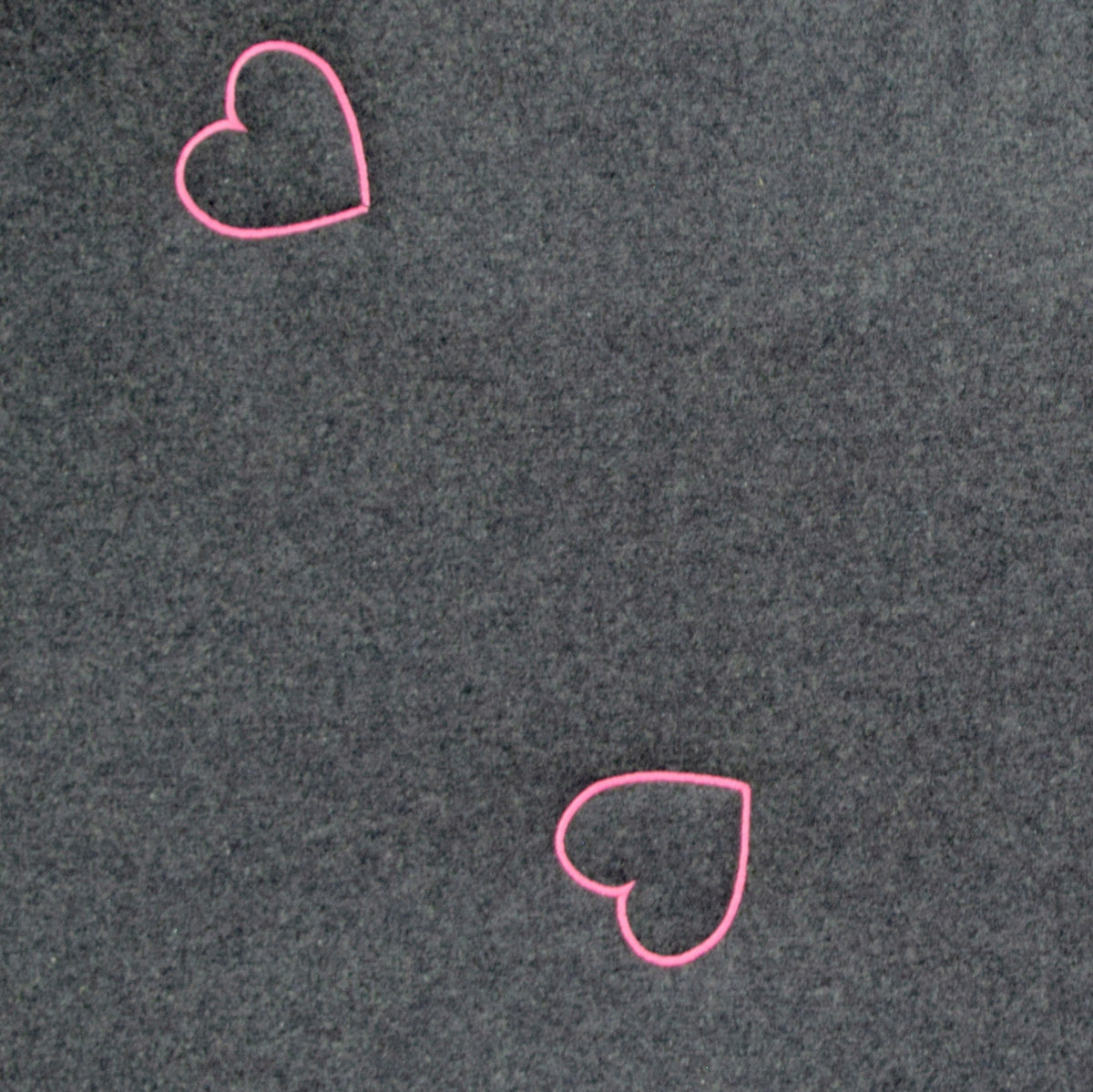 Detailaufnahme des Hundereisebetts Dirndl mit pinker Herzenstickerei auf anthrazitfarbenem Tiroler Tuchloden
