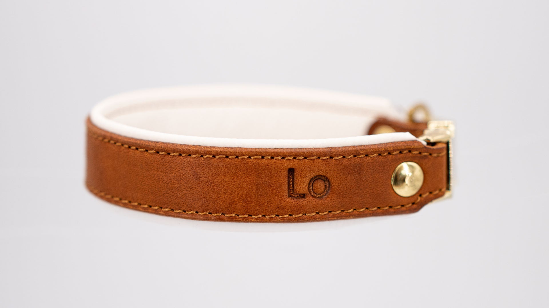 whiskeyfarbenes fettlederhalsband mit weiß hinterlegt, handgefertigt mit messingfarbenen beschlägen