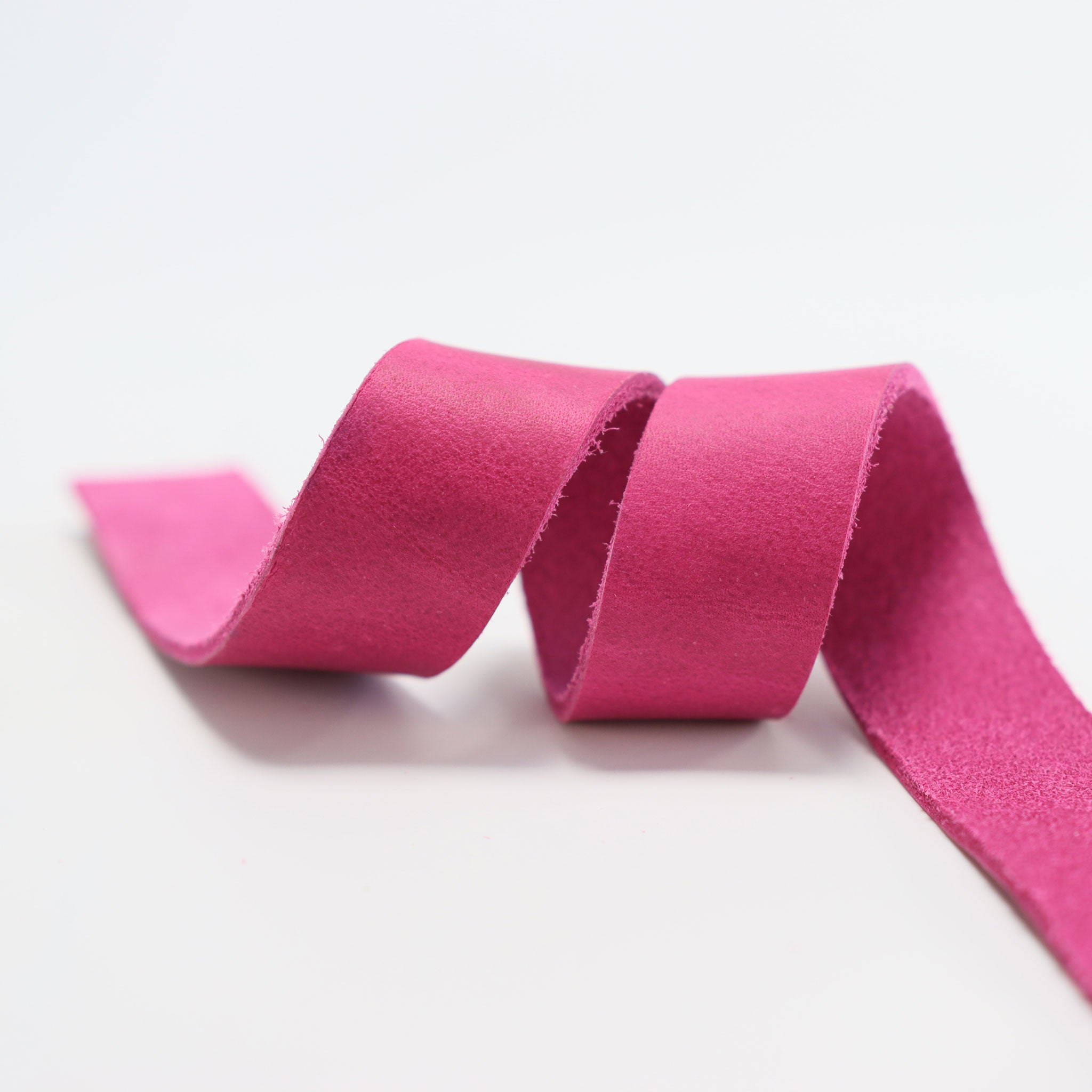 Nahaufnahme eines geschmeidigen pinken Fettlederriemens zur Veranschaulichung der Materialqualität und Farbe.