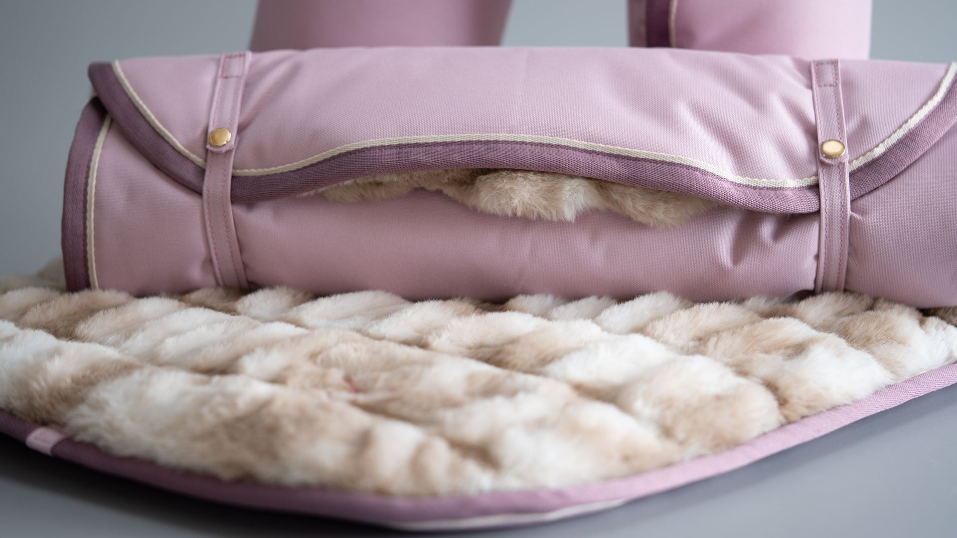 Nahaufnahme des Hundereisebettes, man sieht den Webpelz und das starke Gurtband sehr gut und die Farbe des Aussenmaterials, Puder, läß´t sich sehr gut erkennen