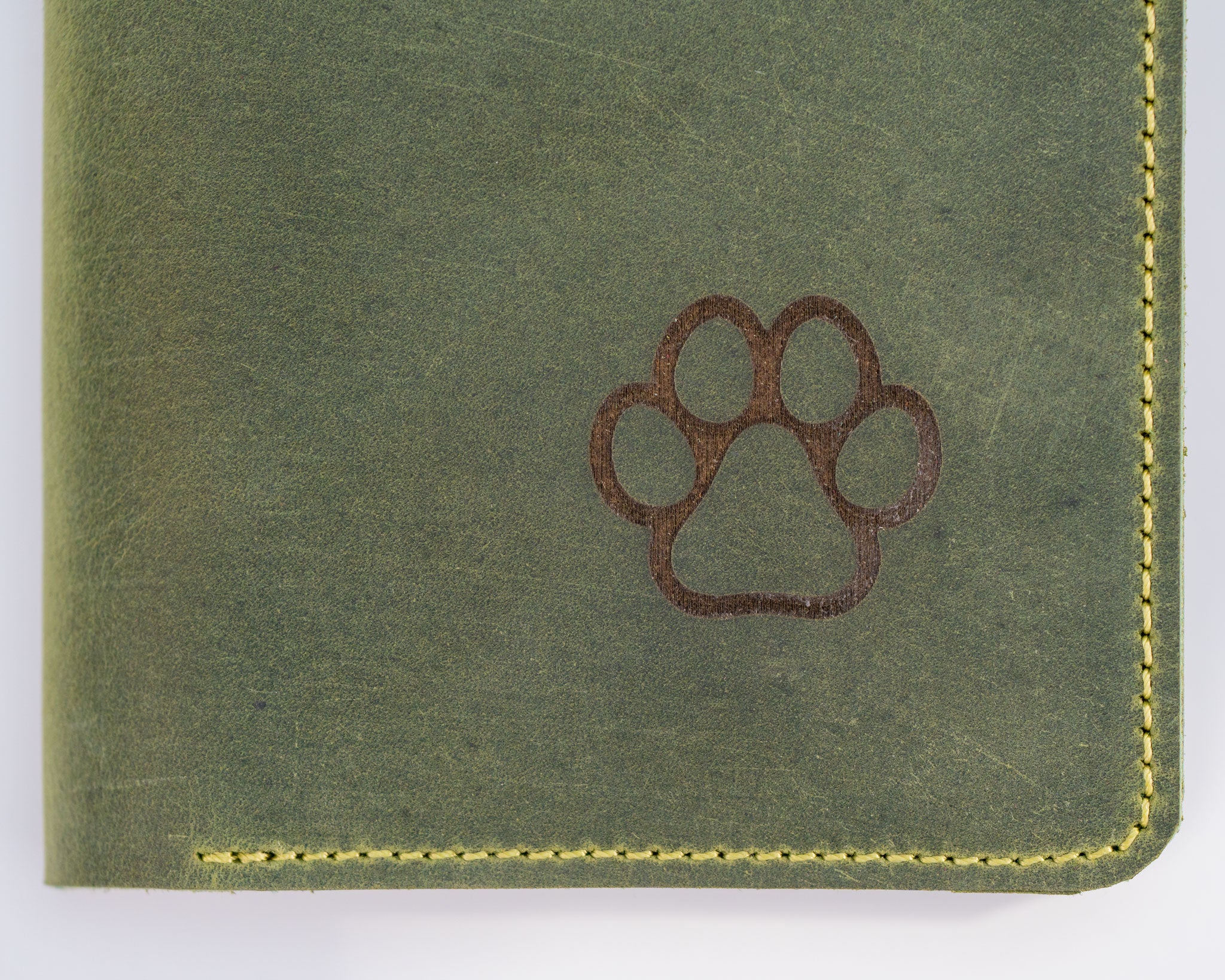 nahaufnahme-crazy-horse-leder-impfpasshülle-für-haustiere-mit-pfotengravur-in-hunter-green