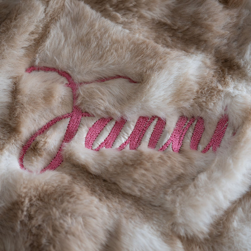 Detailansicht des gestickten Namens "Fanni" im Webpelz