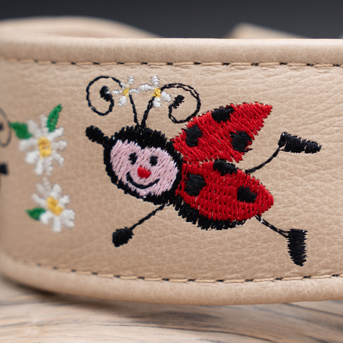 Nahaufnahme der hochwertigen Marienkäfer-Stickerei auf anilingefärbtem Nappaleder.