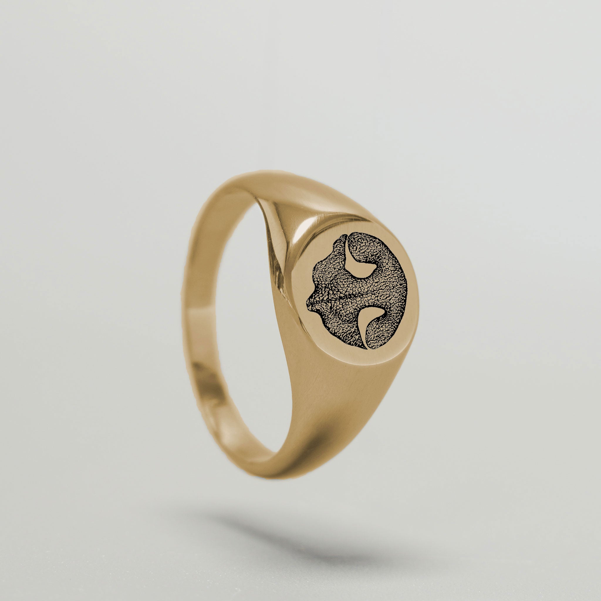 Detailaufnahme der Gravur eines Tier-Nasenabdrucks auf einem Goldring