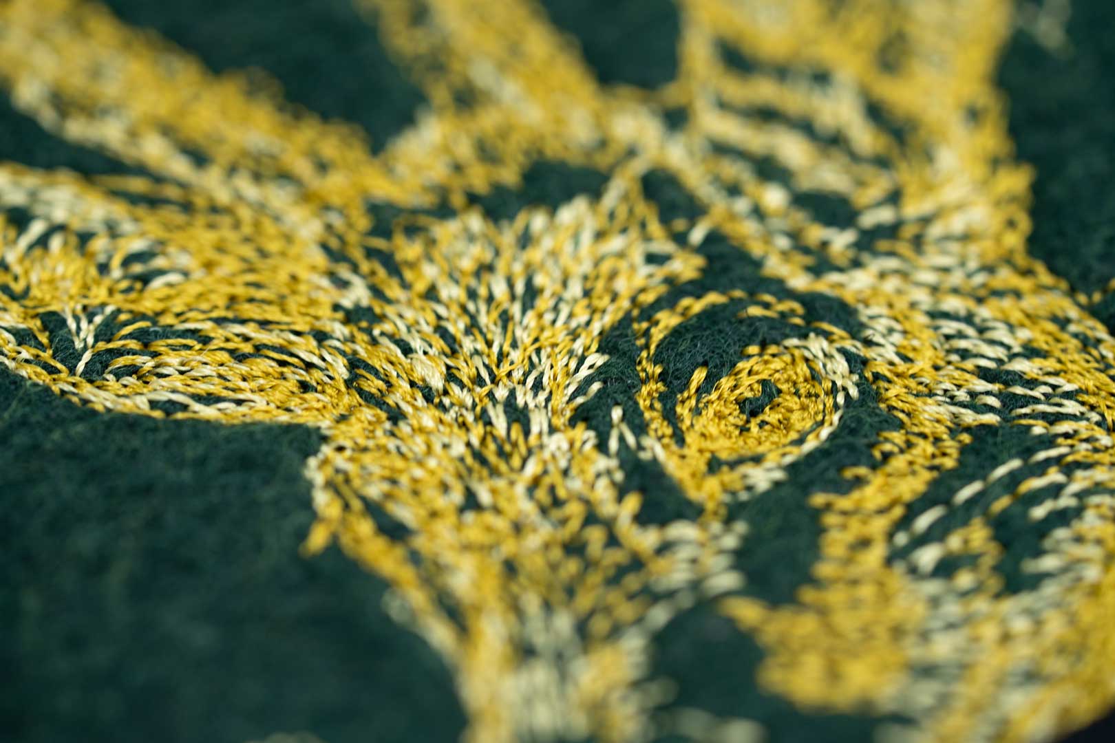 Detail der Rehbock-Stickerei auf dunkelgrünem Filz