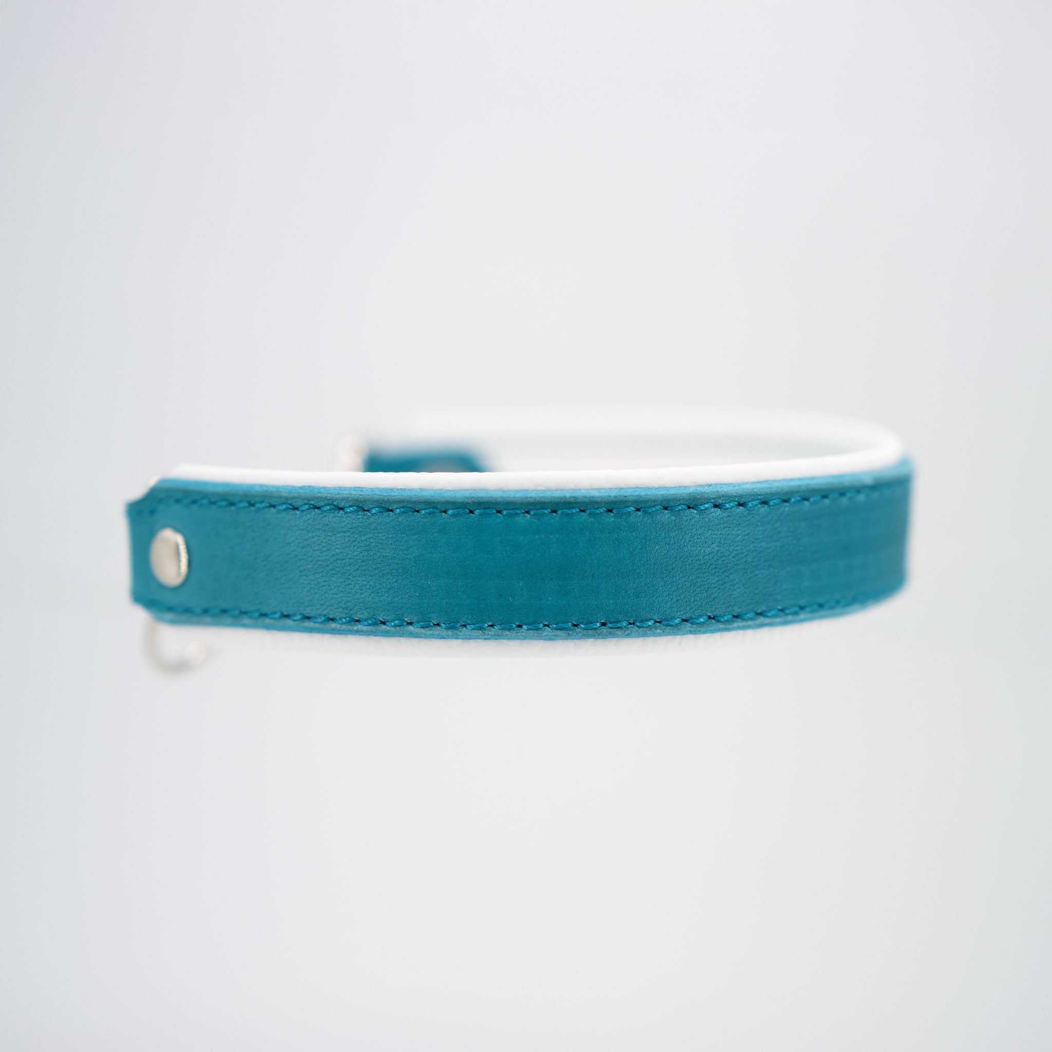 Seitenansicht eines handgefertigten Lederhalsbands in Türkis mit silbernem Nietendetail